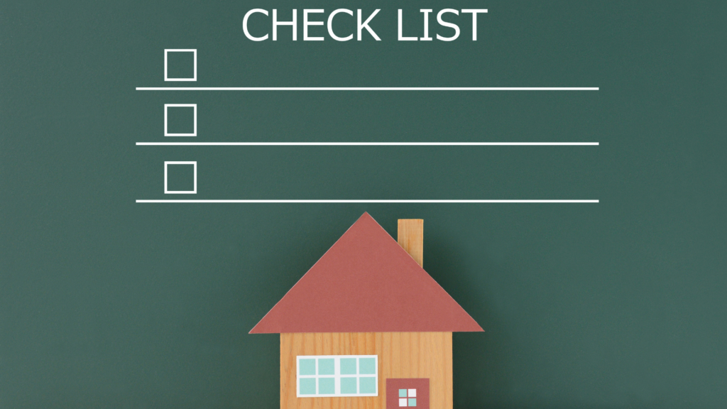 A checklist with three empty boxes is displayed above a small wooden house model against a green background. The word CHECK LIST is written at the top in white letters.